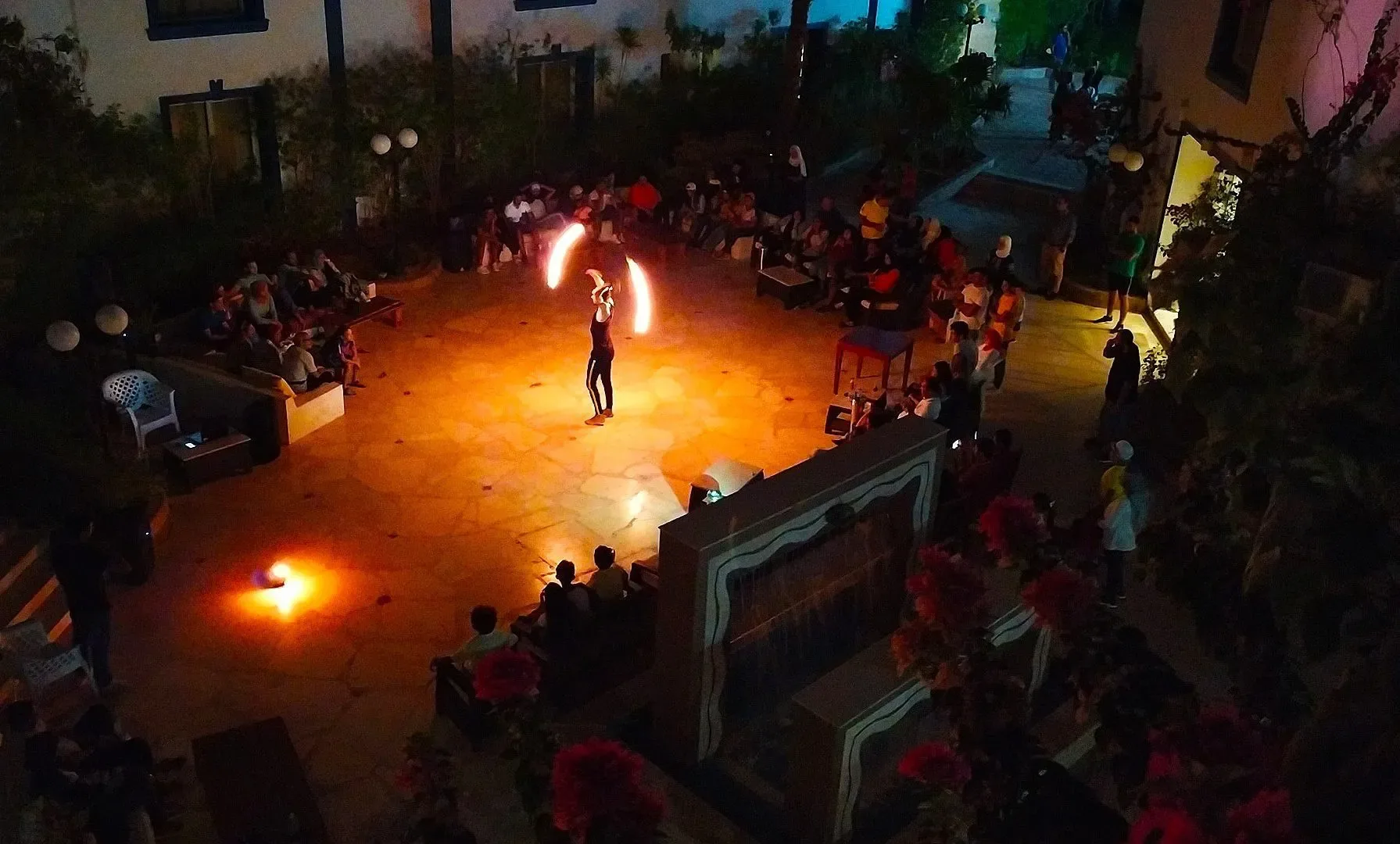 Spettacolo serale di giocoliere con il fuoco nel cortile dell'hotel con pubblico