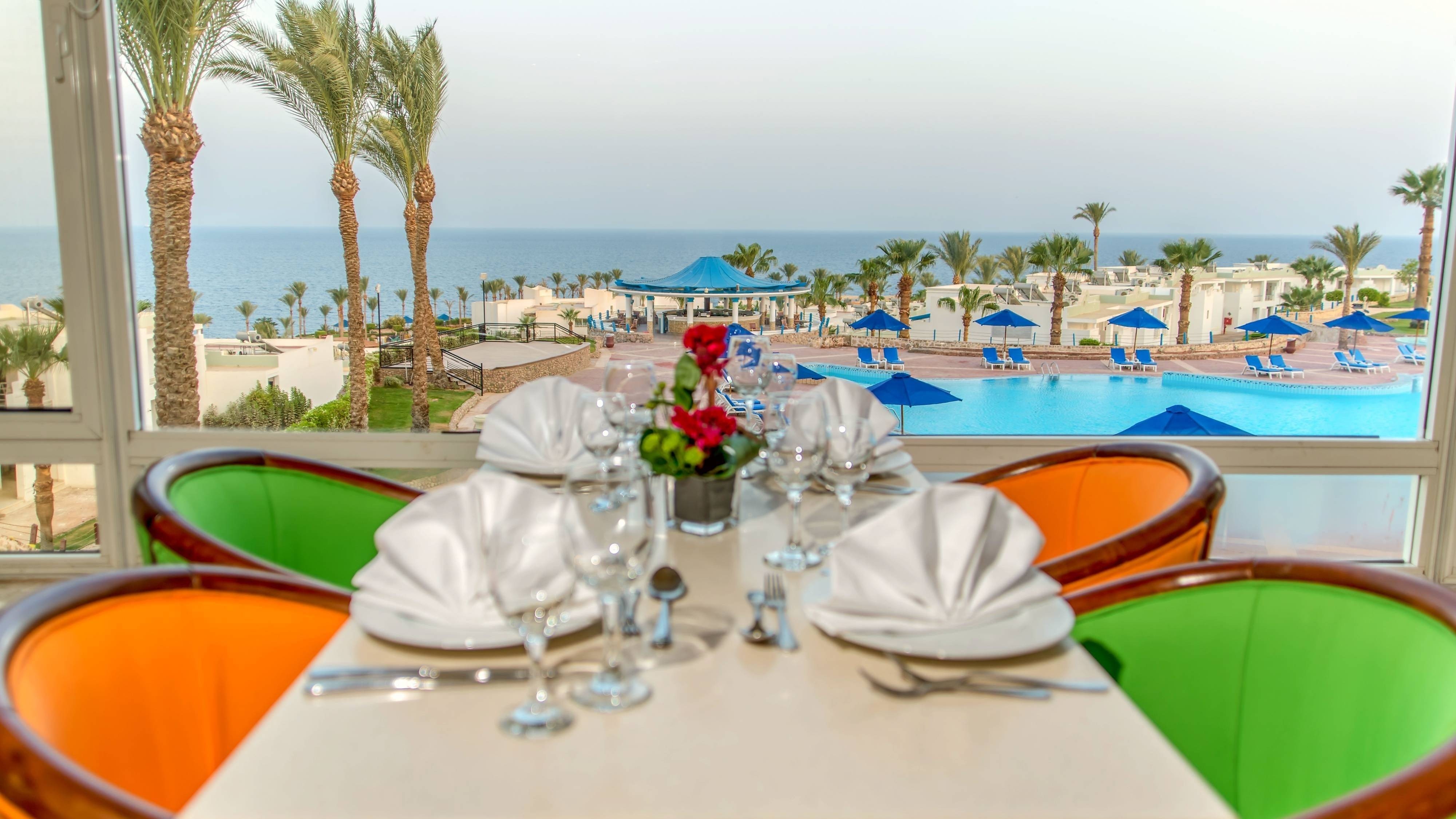 Tavolo apparecchiato del ristorante con vista panoramica sulla piscina e sul mare