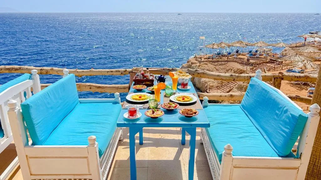 Tavolo con colazione servita su terrazza affacciata sul mare e sulla spiaggia