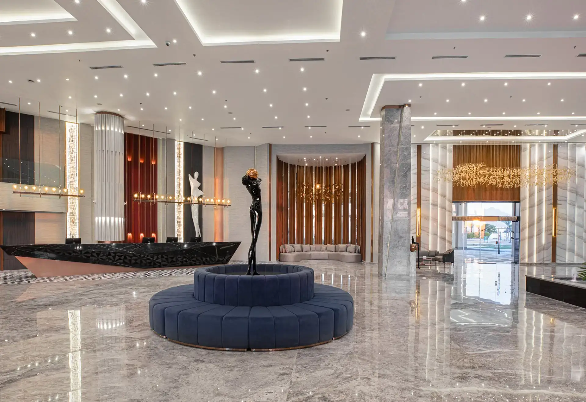 Elegante hall del resort con pavimento in marmo, statua e divano circolare blu